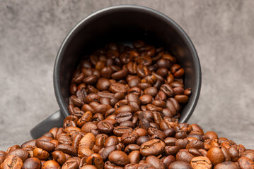 Selective focus and Close-up roasted coffee beans and black mug background
