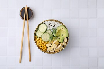 Delicious poke bowl with vegetables, tofu, avocado and microgreens served on white tiled table,...