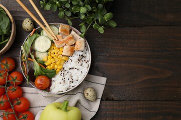 Delicious poke bowl and ingredients on wooden table, flat lay. Space for text