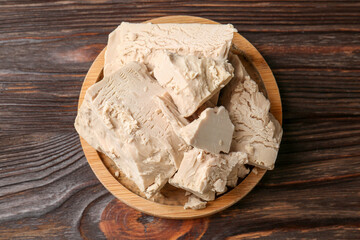 Compressed yeast on wooden table, top view