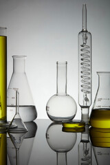 Laboratory glassware containing yellow liquid with reflection on the table. Laboratory experience...