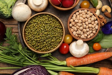 Different vegetables on wooden table, flat lay. Vegan diet