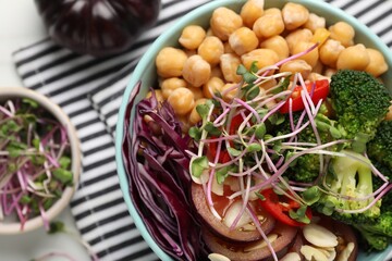 Delicious vegan bowl with broccoli, red cabbage and chickpeas on white table, flat lay