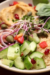 Delicious vegan bowl with cucumbers, spinach and bulgur, closeup