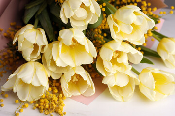 Bouquet with beautiful tulips and mimosa flowers on white marble table