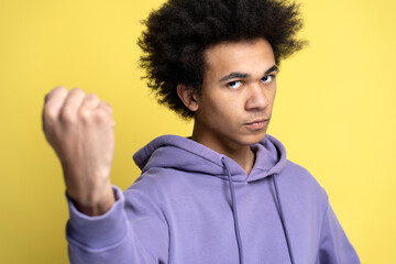 Angry African American man holding clenched fist up ready to fighting