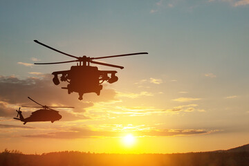 Naklejka na ściany i meble Silhouettes of helicopters on background of sunset. Greeting card for Veterans Day, Memorial Day, Air Force Day. USA celebration.