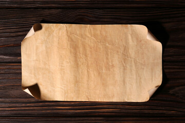 Sheet of old parchment paper on wooden table, top view