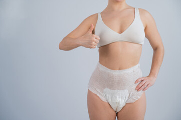 Woman in adult diapers showing thumbs up. Urinary incontinence problem. 