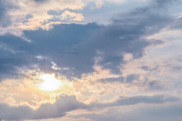 Naklejka na ściany i meble Cloudy sky background with sunlight through clouds