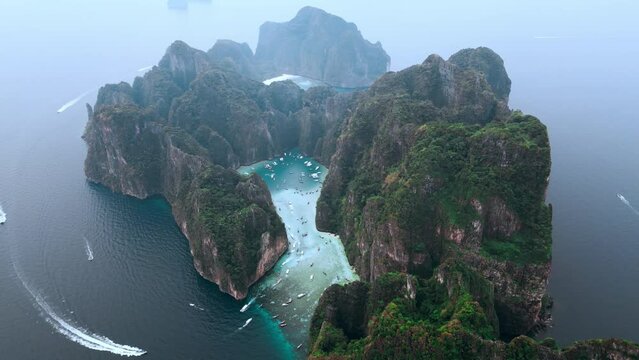 Cinematic aerial view tropical island Ko Phi Phi Lee with iconic Maya Bay and Pileh Lagoon surrounded cliffs on Phi Phi islands in Thailand. Beautiful natural tropical national park island in sea