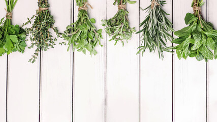 Fresh green herbs on white wooden table, top view