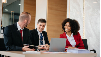 Group of young business people discussing business plan at modern startup in creative business discussing work modern office building.