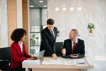 Group of young business people discussing business plan at modern startup in creative business discussing work modern office building.