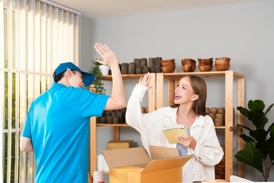 Asian delivery man and Caucasian owner woman they are partner and tag team when success service order to customer at home office