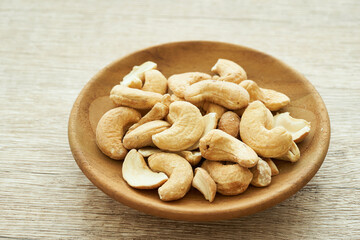 cashew nut in wood plate on wooden table background. pile of cashew nut background. cashew nut                       