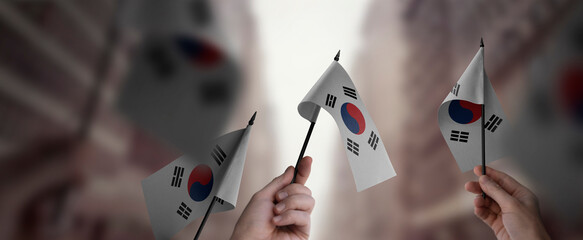 A group of people holding small flags of the South Korean in their hands