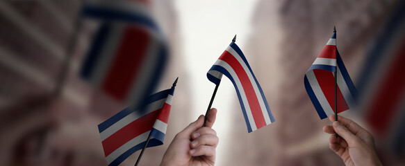 Naklejka premium A group of people holding small flags of the Costa Rica in their hands