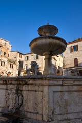 Beautiful view of famous Piazza del Comune with historic fountain figuring three lions and ancient palaces in the background on the main sqaure of Assisi, Umbria, Italy