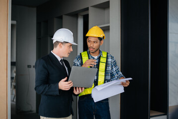 Architect caucasian man working with colleagues mixed race in the construction site. Architecture engineering on big project. Building in construction interior..