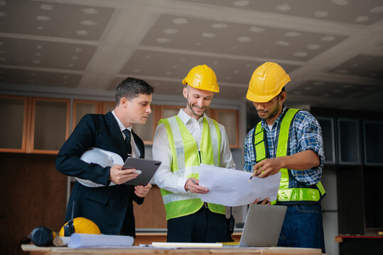 Engineer teams meeting working together wear worker helmets hardhat on construction site in modern city.