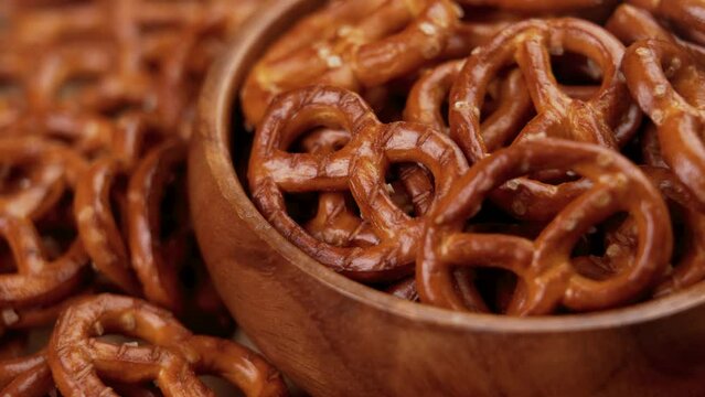 Crispy pretzel crackers with salt crystals in wooden bowl. Traditional beer snack close up. Rotation