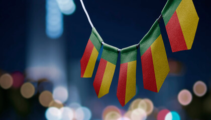 A garland of Benin national flags on an abstract blurred background