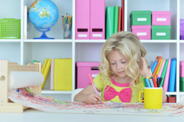girl drawing picture at desk at home