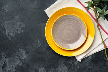 Top view of ceramic plate with table napkin on gray background
