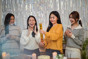 Cheerful friends enjoying home Birthday holiday party. Asian Friends celebrating Christmas or New Year eve party.