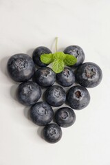 Fresh blueberries with mint leaves. The fruits are actual berries with many tiny seeds and are deep indigo to black color when ripe. Copy space.