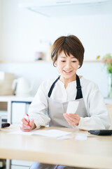 レシートを確認するエプロン姿の女性