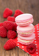 French makarons cake . Pink raspberry macaron cookies on dark wooden boards