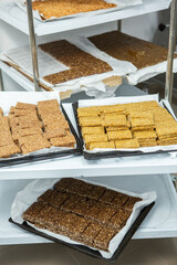 Assortment of cereal or protein bars that leave the assembly line at the factory. Healthy pre or post workout snacks with fruits, nuts and berries. 