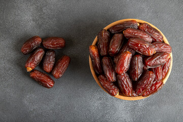 Date fruits in wooden bowl,on black background
