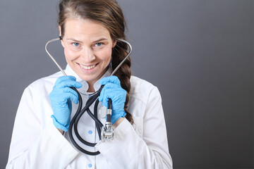 portrait of a young woman doctor with a stethoscope in sterile gloves close-up