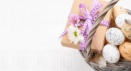 Fototapeta na wymiar Gift box with flowers and Easter eggs basket