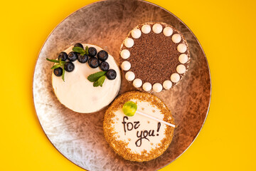 Three bento cakes with different designs on a yellow background.