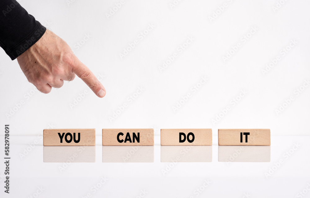 Poster you can do it. hand pointing towards the wooden blocks with the message you can do it. personal moti
