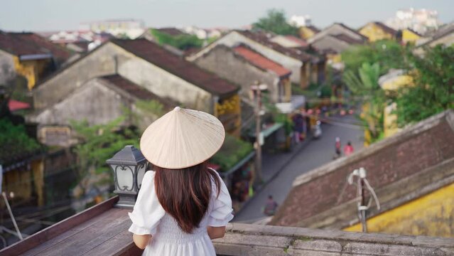 Young female tourist looking at Hoi An Ancient town in Vietnam
