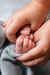 The concept of happy motherhood, family, care. Little baby feet close up. Parents' hands