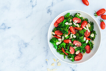 Broccoli salad with cherry tomatoes and almonds in white bowl. Vegan detox recipe.