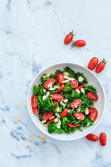Broccoli salad with cherry tomatoes and almonds in white bowl. Vegan detox recipe.