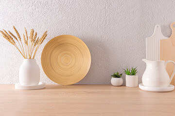 Fototapeta na wymiar part of the interior of a modern kitchen in light colors. eco-friendly items, bamboo dish, ceramic jug, vase with ears of corn.