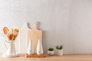 modern kitchen background with a copy space on a gray concrete wall. cutting boards, a jug with wooden tools.