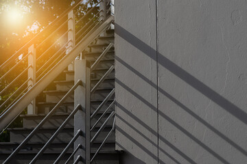 Background of blurry shadow from handrail shown on white rough cement wall with sunrise and copy space.