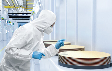 Worker or engineer wears medical protective suit or coverall suit with silicon wafer