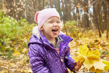 girl is sitting on a fallen tree log in the autumn sunny yellow forest