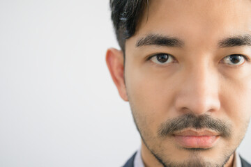 Portrait of a handsome Asian man with a beard in a gray shirt with suit making a straight face.