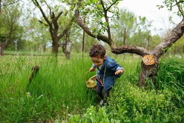 Boy with basket, walking bent under tree branch 